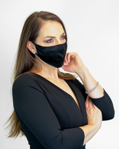Elegant gekleidete Frau mit schwarzer Mundschutz-Seidenmaske